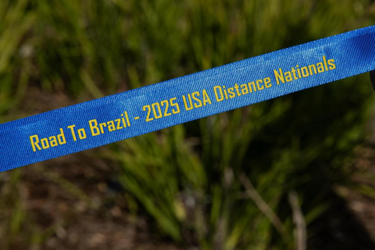 Banner saying "Road to Brazil - USA 2025 Distance Nationals" in front of a field of grass